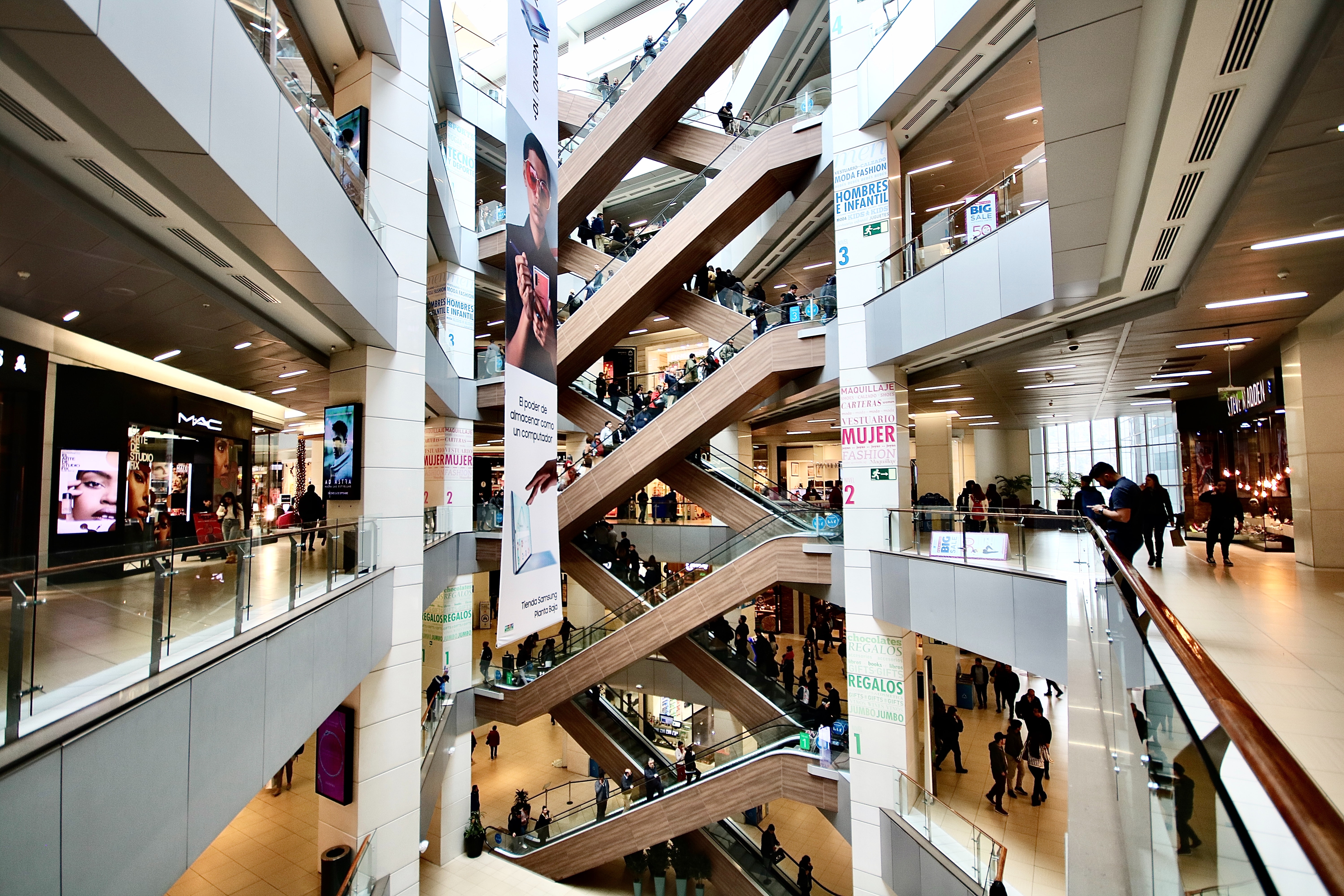 shopping mall interior with people and escalators