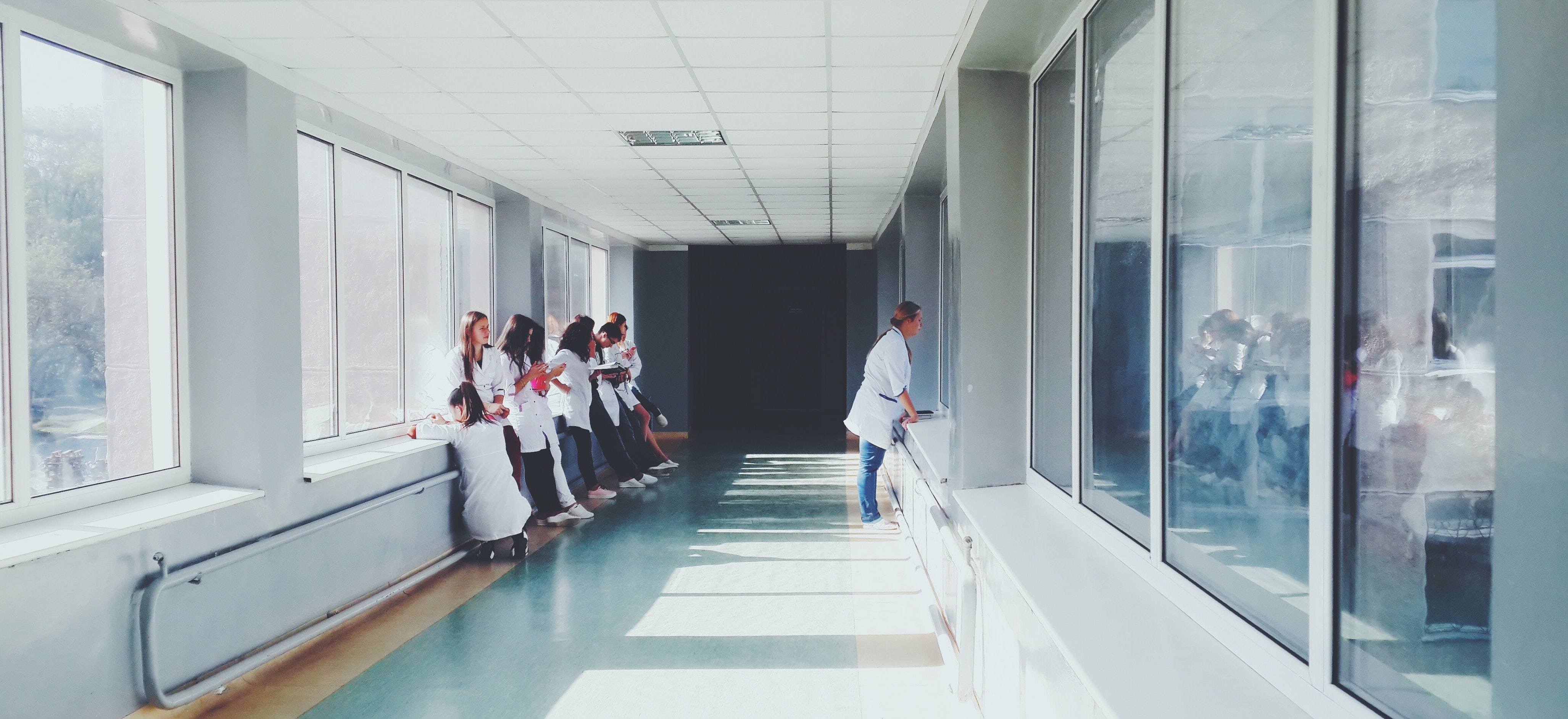 woman-in-white-shirt-standing-near-glass-window-inside-room-127873-cropped